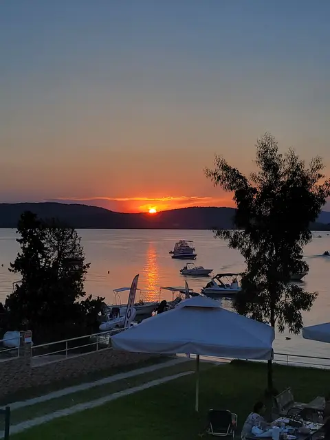 Orange sunset over the bay with boats silhouetted on the water