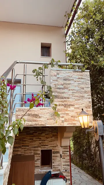 Stone facade with a flowering balcony and lantern