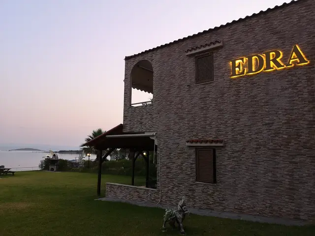 The EDRA sign glowing at dusk on the stone facade