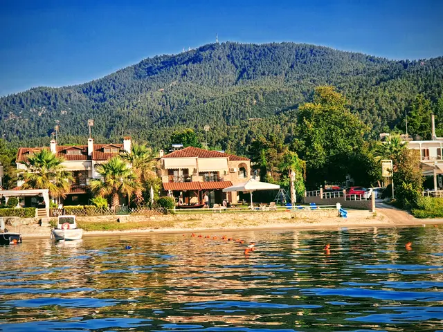 Boats moored along Vourvourou beach with the mountain behind
