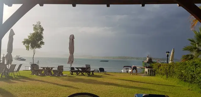 Covered terrace with a dining table looking at the sea at dusk